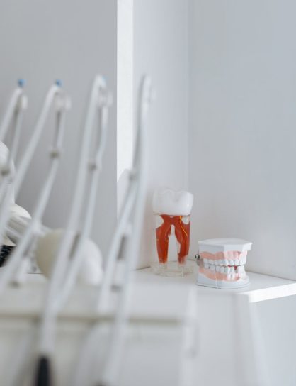 Close-up of dental tools and anatomical models in a well-lit clinic, highlighting oral hygiene and dentistry concepts.